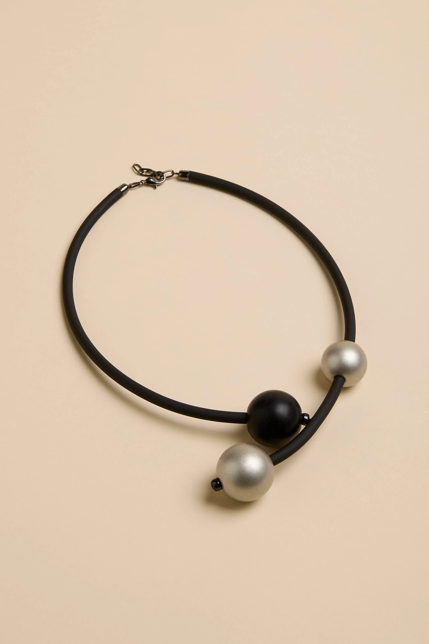 Triple Sphere Statement Necklace featuring a black cord with one black sphere and two silver spheres.