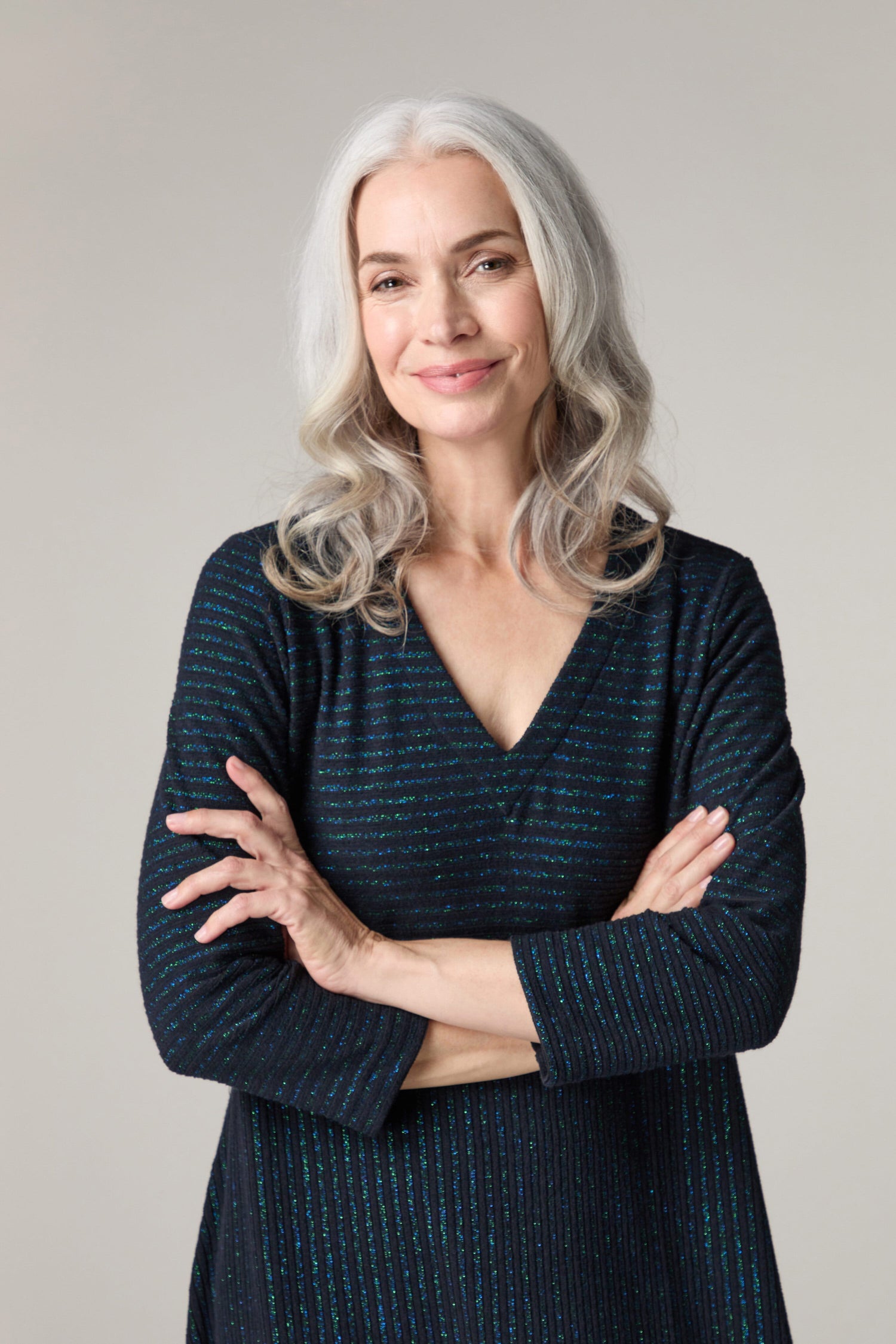 A woman with gray hair posing in a relaxed fit Stripe Lurex Jersey Dress for a photo, creating a geometric look.