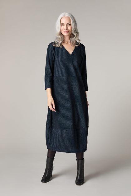 The woman is wearing a blue Stripe Lurex Jersey dress.