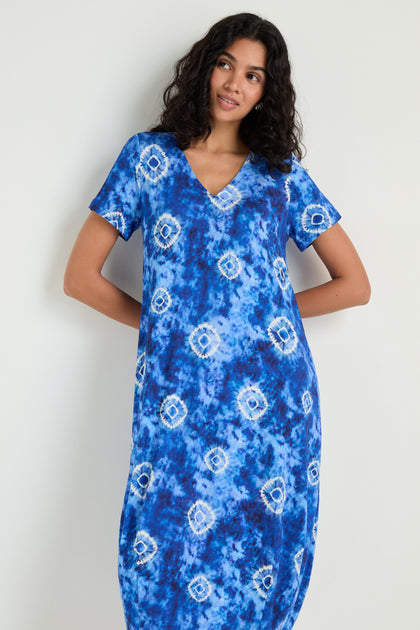 A woman models the Tie Dye Circles Jersey Bubble Dress, featuring short sleeves and a V-neck, against a plain light-colored background.