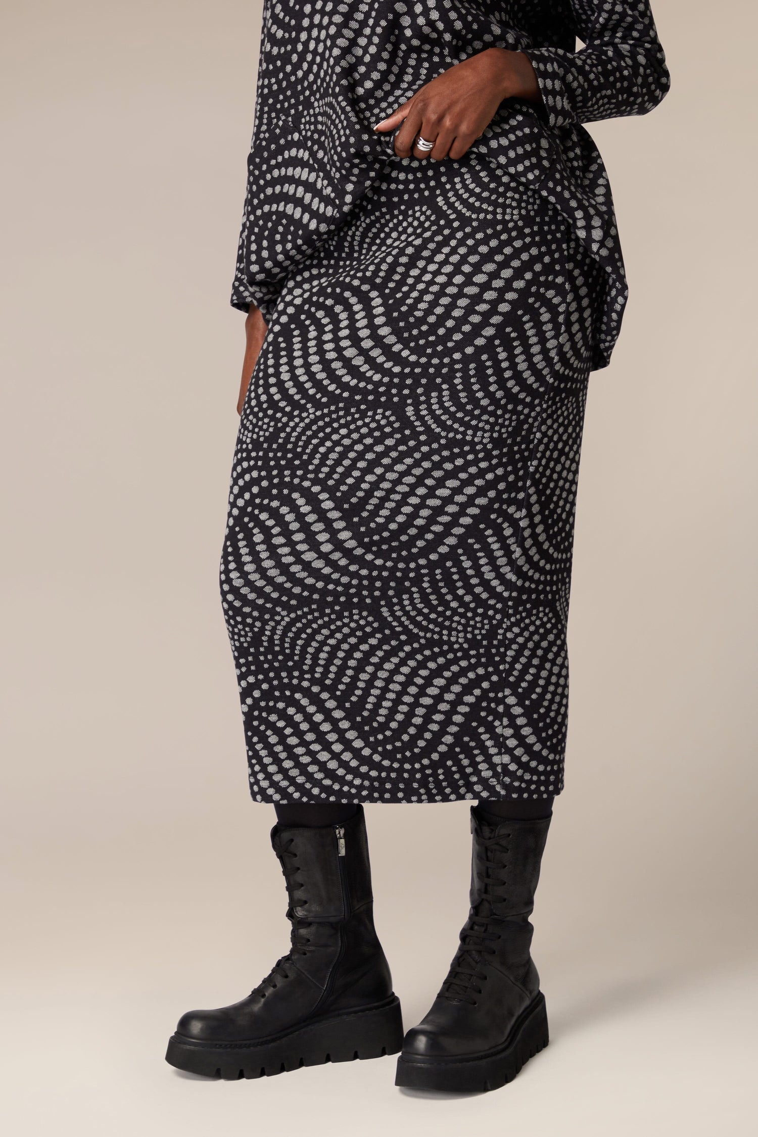 A woman wearing a Spiral Spot Jersey Tube Skirt made of jersey material.