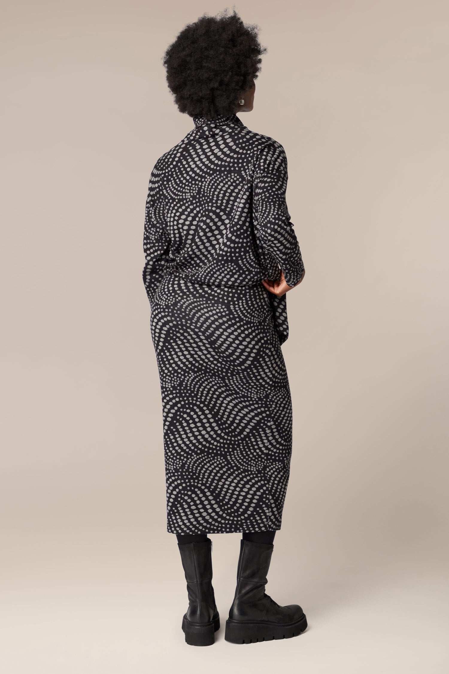The back view of a woman wearing a unique Spiral Spot Jersey Tube Skirt made from jersey material.