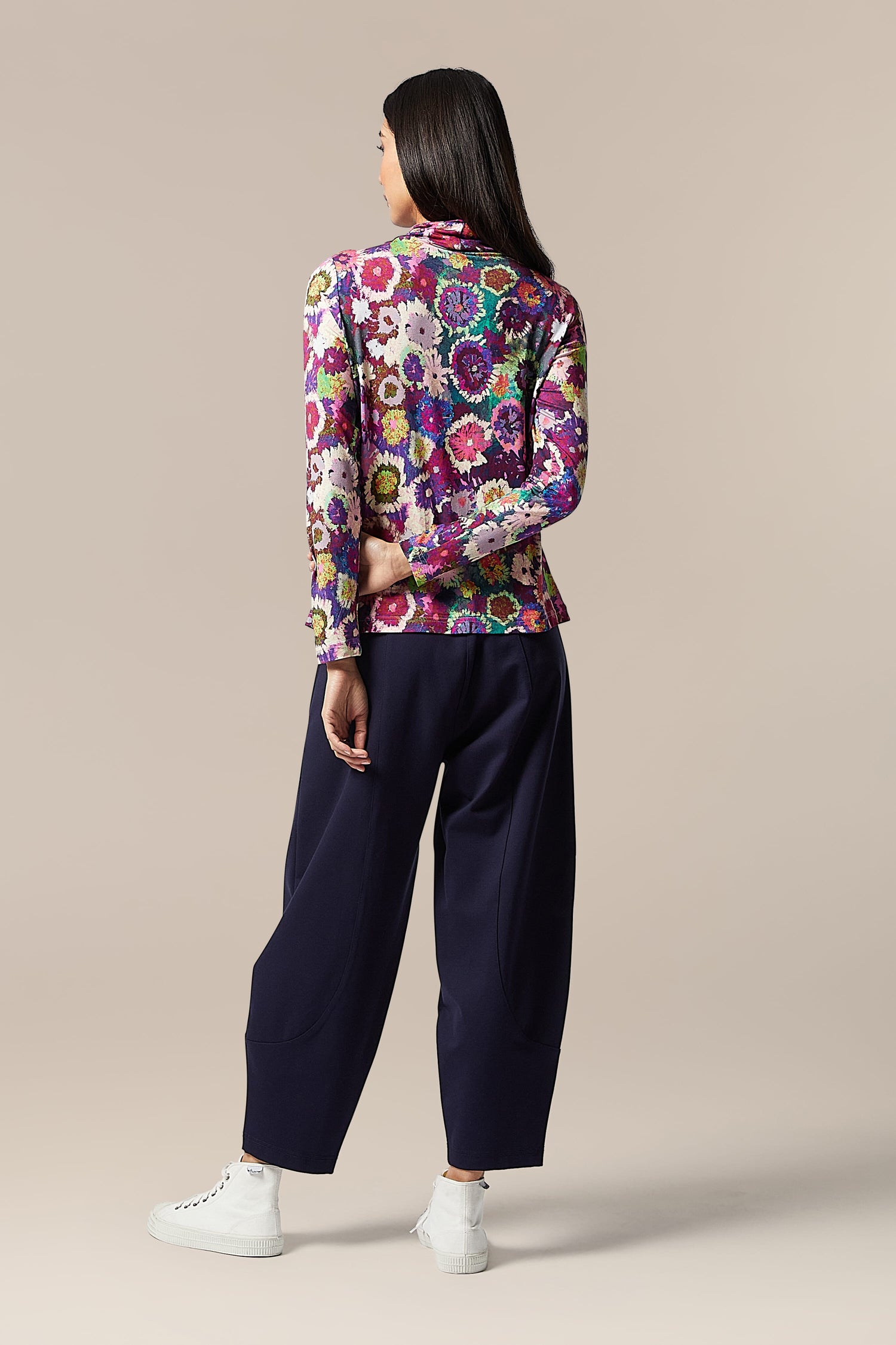 The saturated back view of a woman wearing a Midnight Garden Jersey Polo Neck jacket.