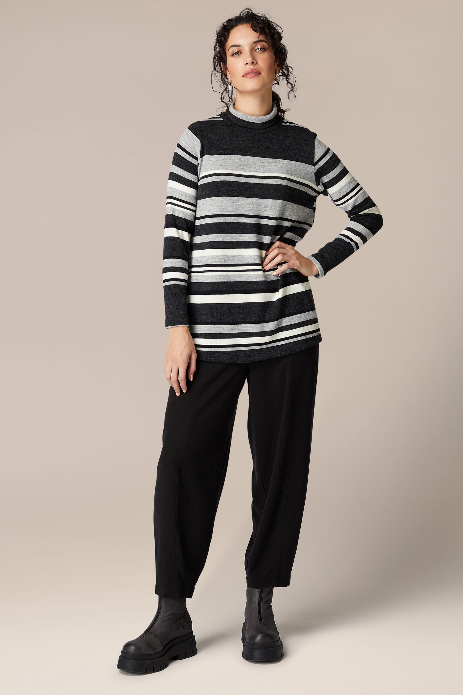 The woman exudes sophistication and comfort in her black and white Jersey Stripe Knit Polo Top.