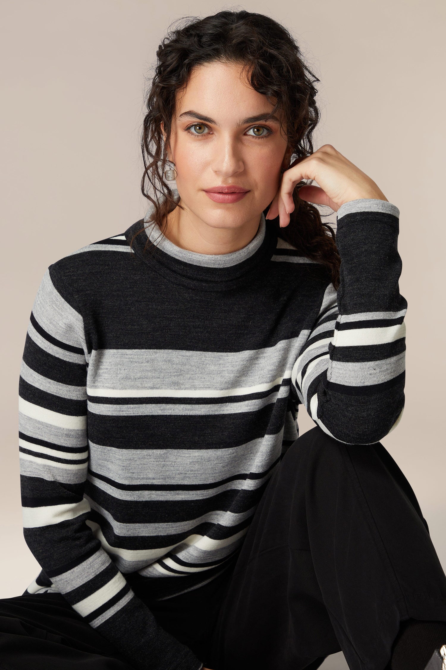 A woman showcasing her sophistication in a cozy Jersey Stripe Knit Polo Top.