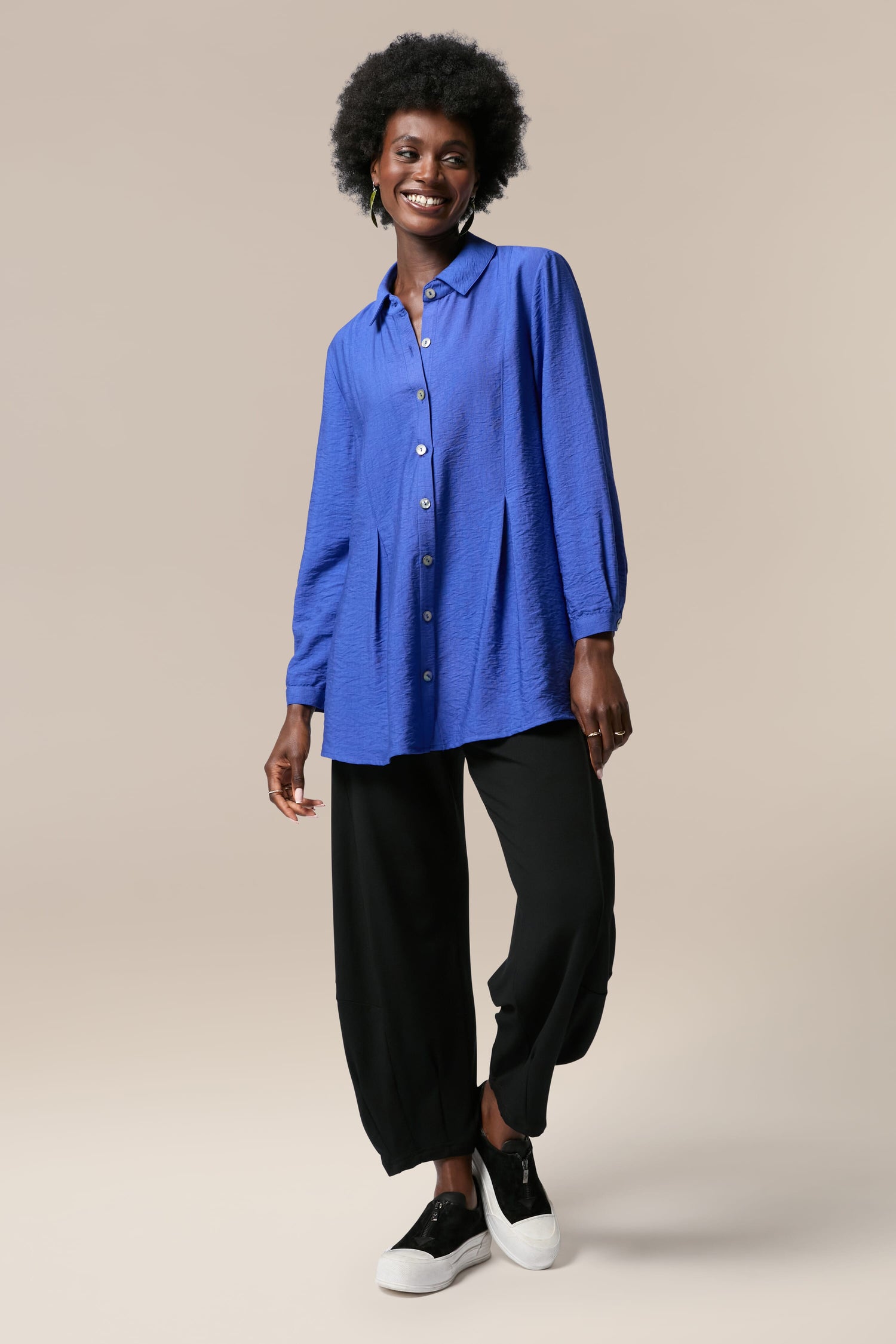 A woman wearing a Textured Viscose Pleat Shirt and black pants for a formal occasion.