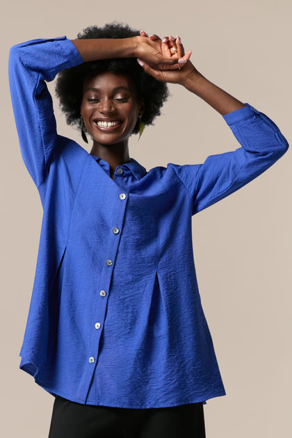 A woman wearing a Textured Viscose Pleat Shirt and black pants.