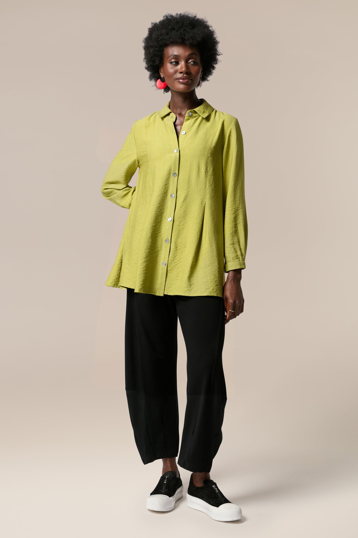 A woman wearing a Textured Viscose Pleat shirt and black pants.