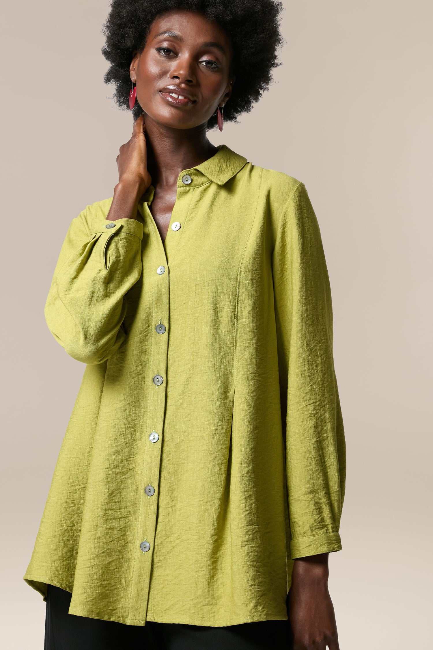A woman wearing a Textured Viscose Pleat Shirt and black pants, perfect for any occasion.