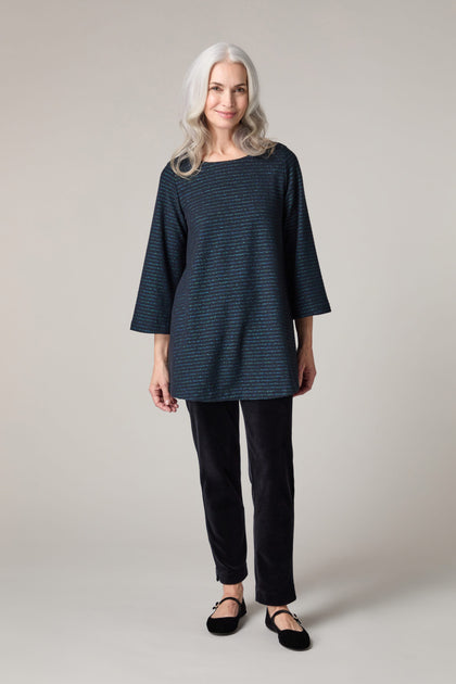 A woman wearing a Stripe Lurex Jersey Top and black pants.