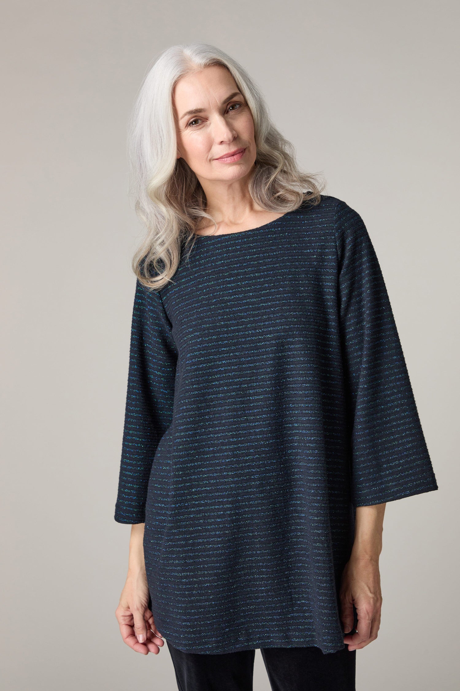 A woman wearing a Stripe Lurex Jersey Top with a touch of sparkle.