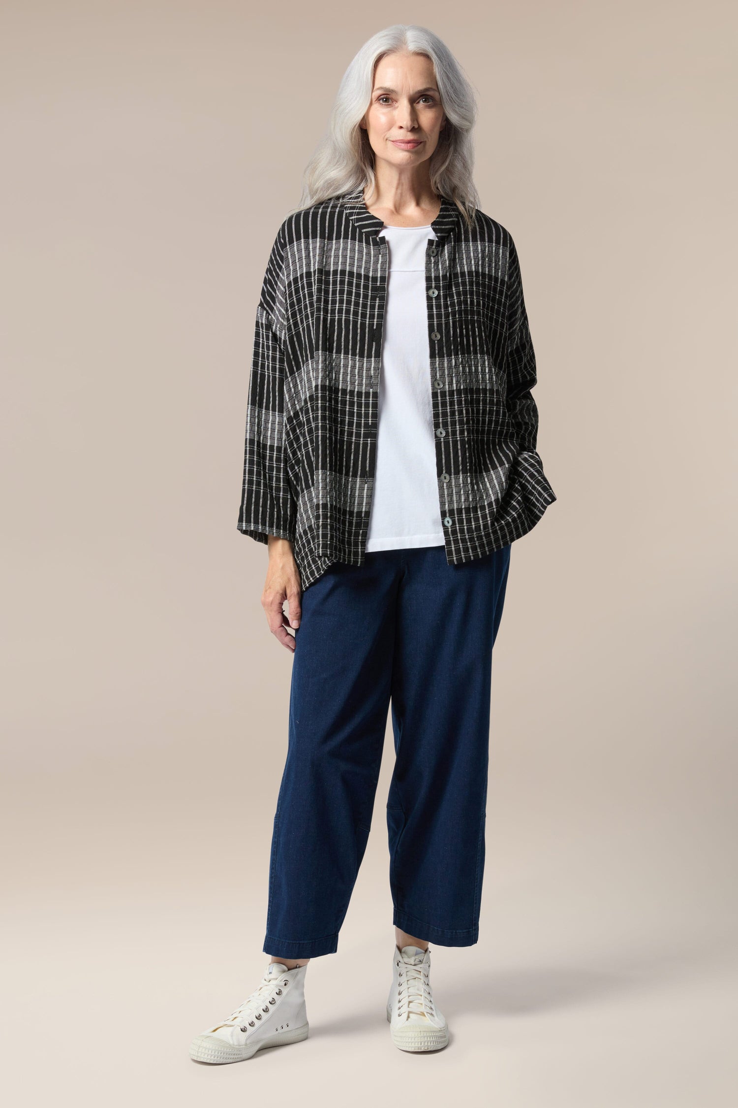 A silhouette of a woman wearing a Gradient Check Shirt and blue pants.