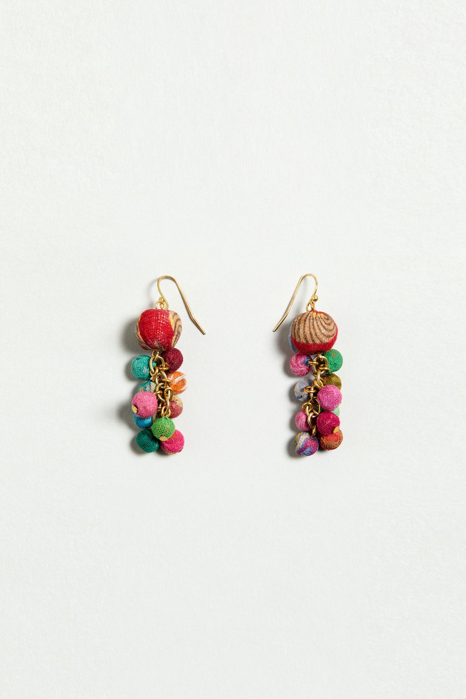 The Kantha Spheres Earrings are colorful handcrafted earrings with clusters of small fabric-wrapped beads in red, green, pink, and blue on gold hooks, shown on a plain white background.