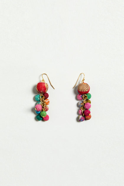 The Kantha Spheres Earrings are colorful handcrafted earrings with clusters of small fabric-wrapped beads in red, green, pink, and blue on gold hooks, shown on a plain white background.