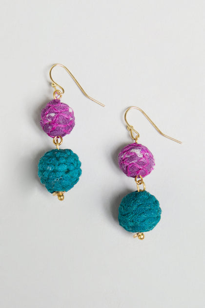 Introducing the Kantha Double Spheres Earrings—each earring features gold hooks with a pink textured cotton-wrapped bead stacked above a larger blue textured bead. These statement earrings infuse vibrant color and artisanal charm into any ensemble.