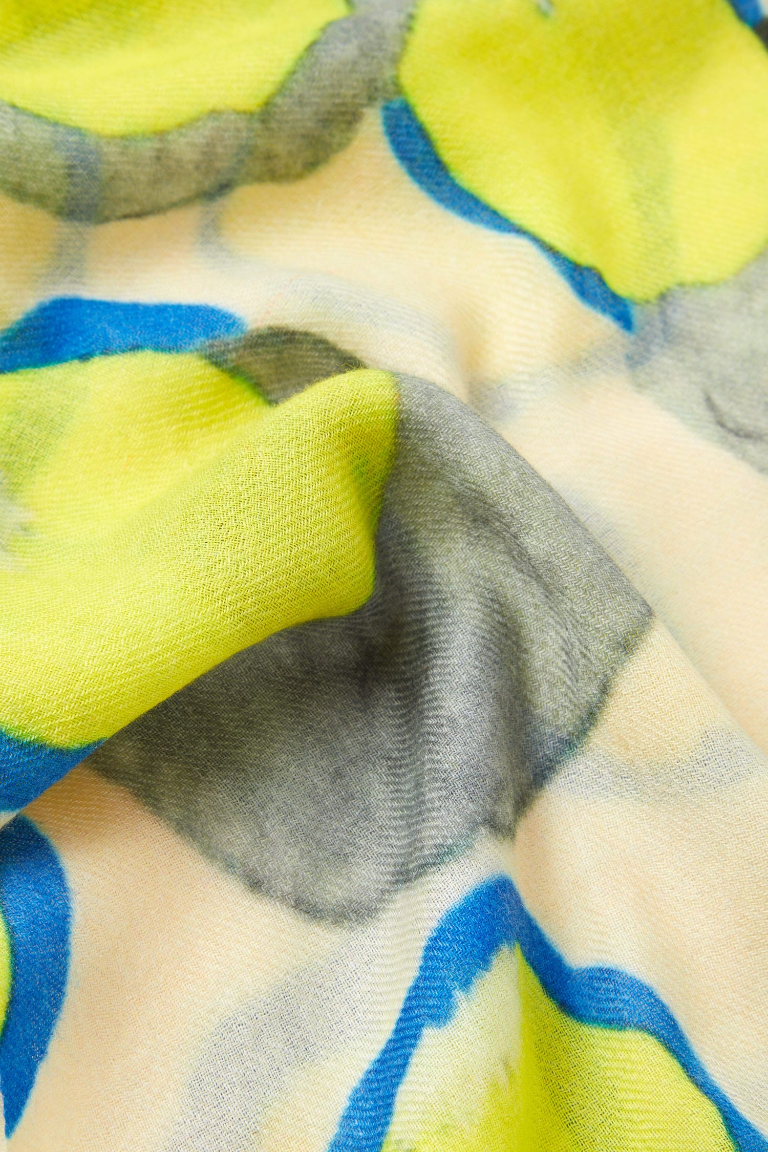 A close up of the Neon Spot Wool Scarf with yellow and blue fabric, making it a statement accessory for all-occasion styling.