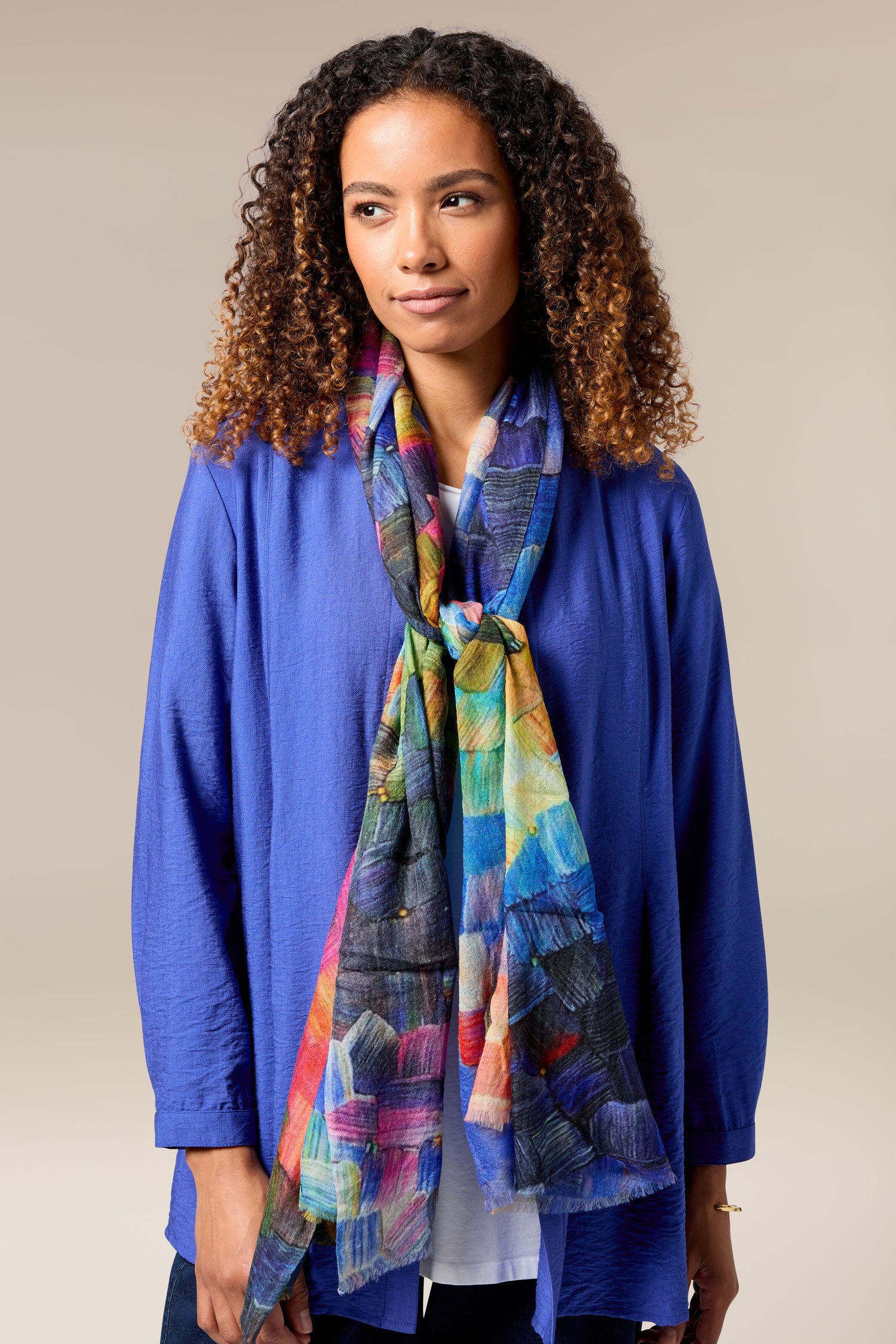 A woman wearing a luxurious blue jacket and Painterly Woollen Scarf as an accessory.