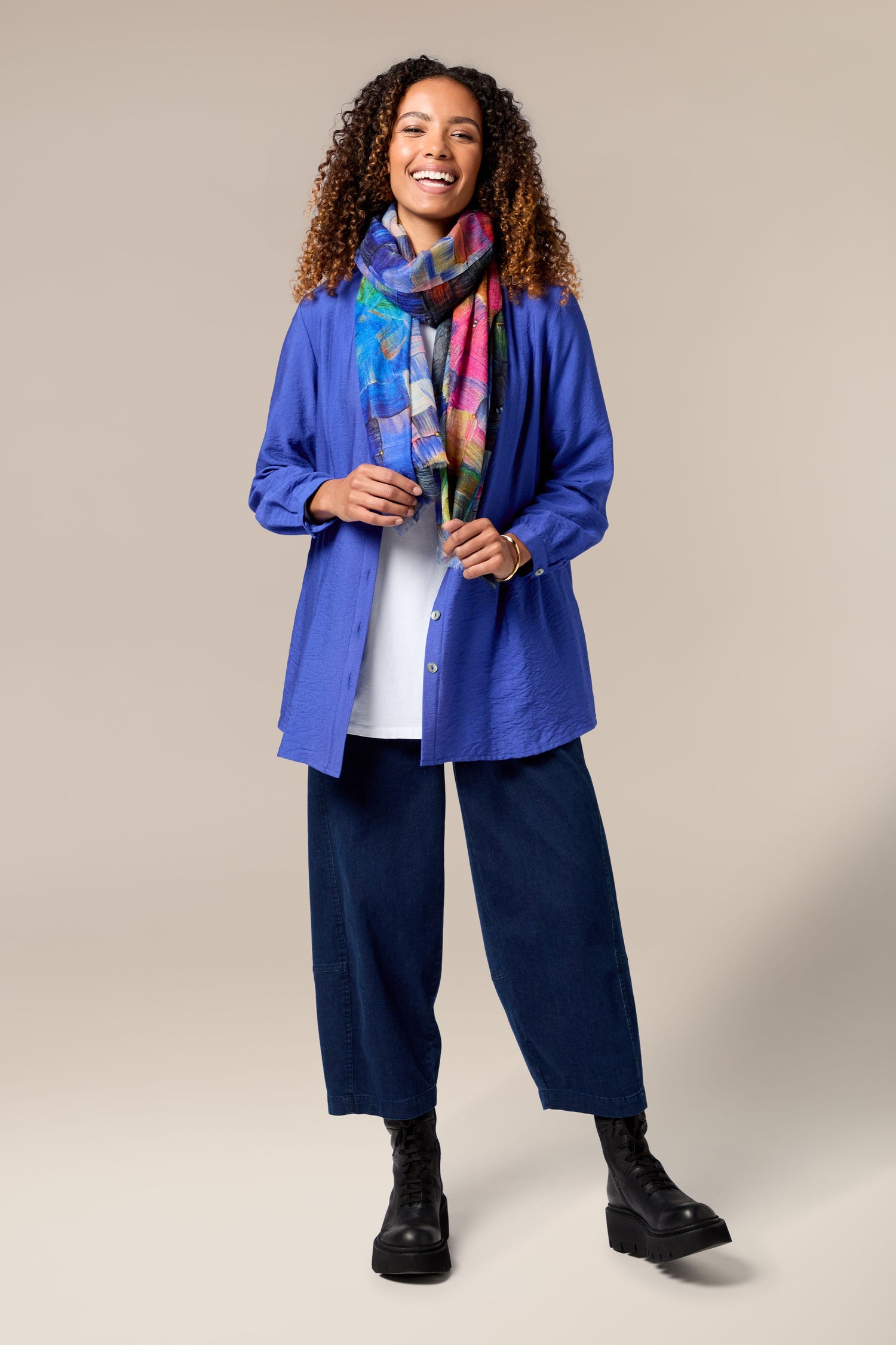 A woman wearing a luxurious blue jacket and blue pants was also donning the Painterly Woollen Scarf.