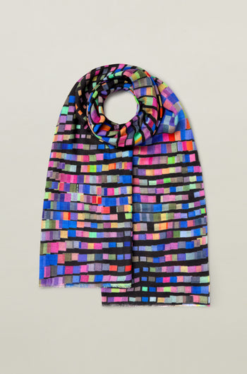 The Graduated Rainbow Squares Wool Scarf features a pattern of small, rectangular blocks arranged in horizontal rows, displayed on a plain gray background. This vibrant color scarf is crafted from premium wool for ultimate comfort and style.