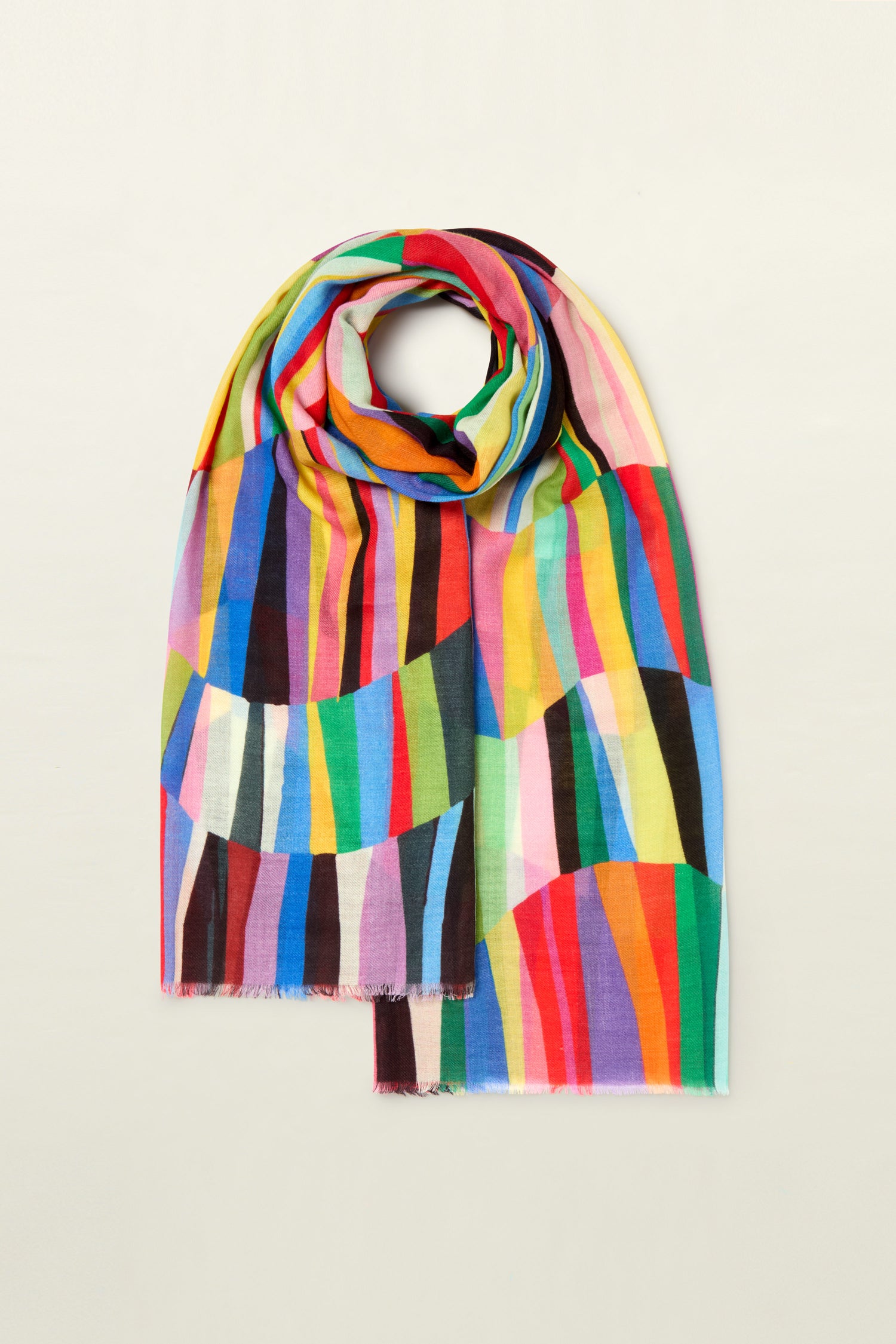 The Geometric Rainbow Stripe Wool Scarf, made from premium wool, features a pattern of vertical and curved stripes in an array of vivid colors, artfully folded and set against a simple backdrop.