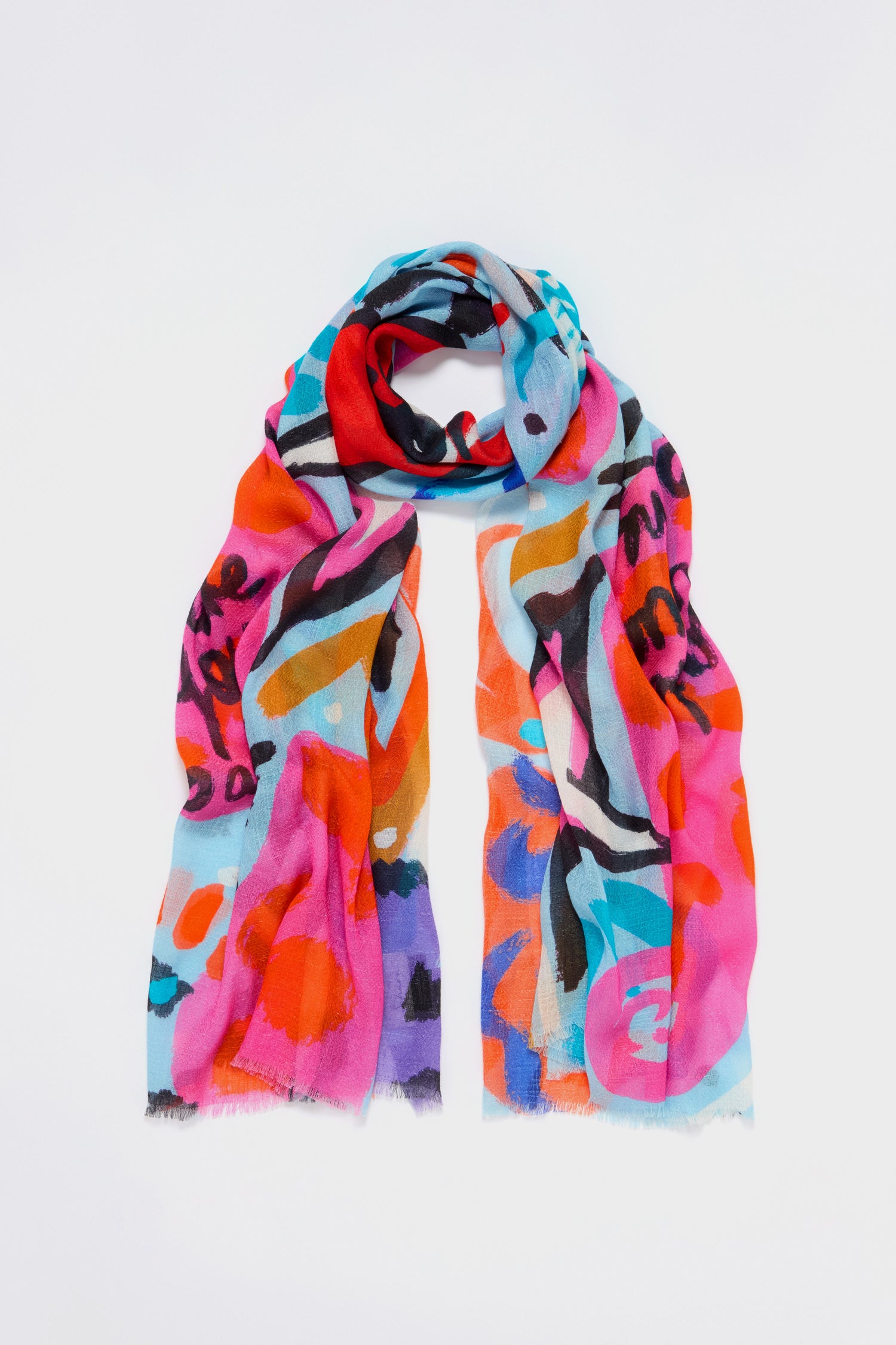 The Painted Stars Cotton Blend Scarf features artistic star motifs across a vibrant, abstract pattern in red, blue, pink, orange, and black against a white background.