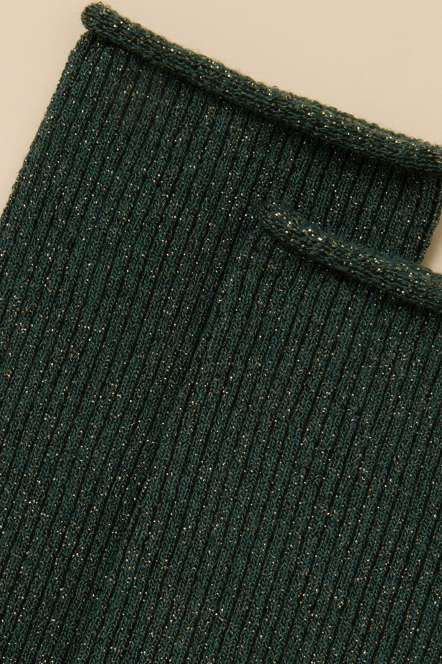 Close-up of Forest Bamboo Sparkle Socks in a dark green, ribbed lyocell-blend knit with a subtle gold metallic shimmer.