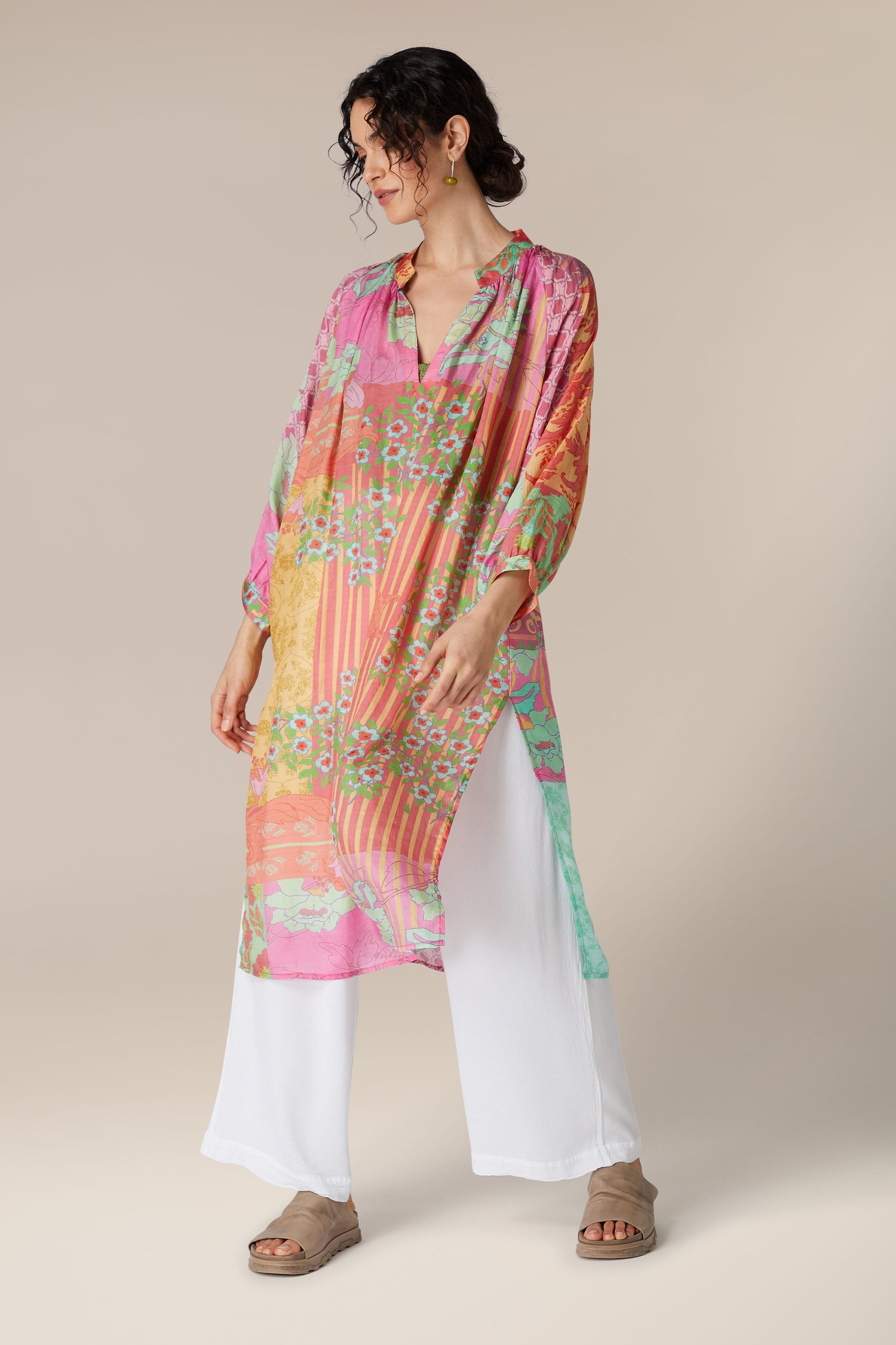 A person wearing a Geometric Floral Silk Beach Dress over white trousers, standing against a neutral background.