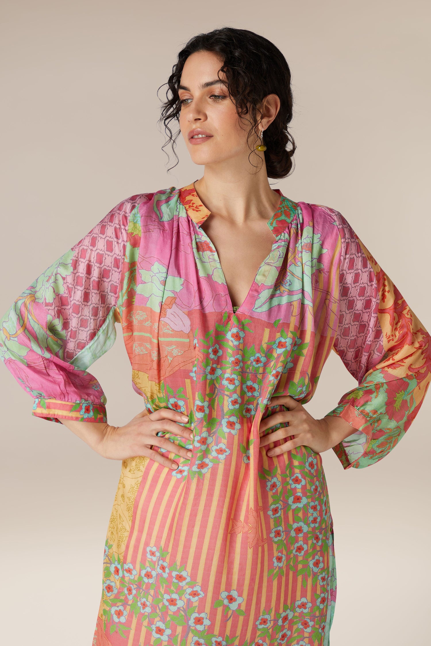 Woman posing in a colorful Geometric Floral Silk Beach Dress with puffed sleeves.