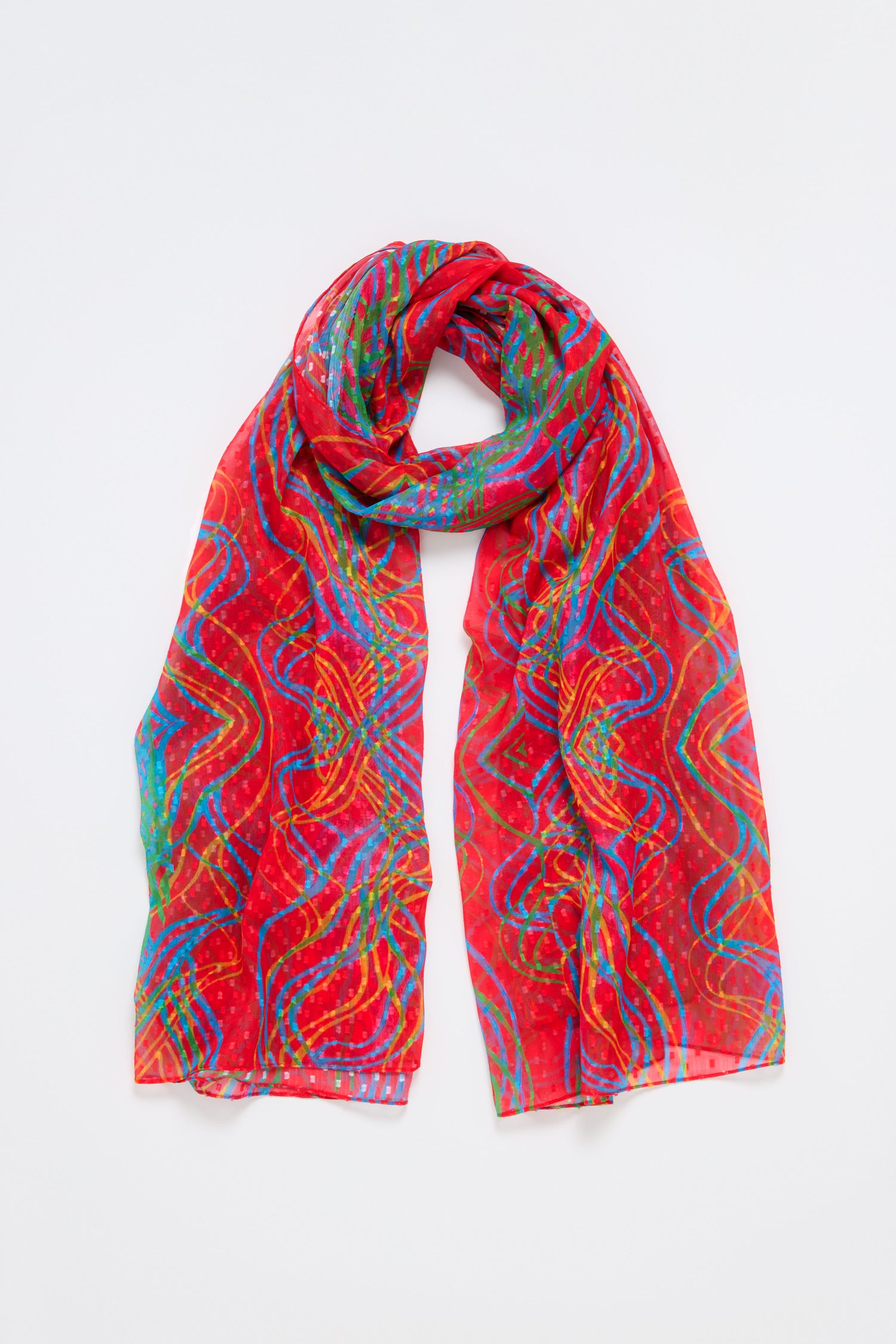 The Twirl Print Dobby Scarf, featuring vibrant red, blue, and green abstract wave patterns, is showcased on a plain white background. Crafted from lightweight dobby fabric, this versatile accessory adds elegance to any ensemble.