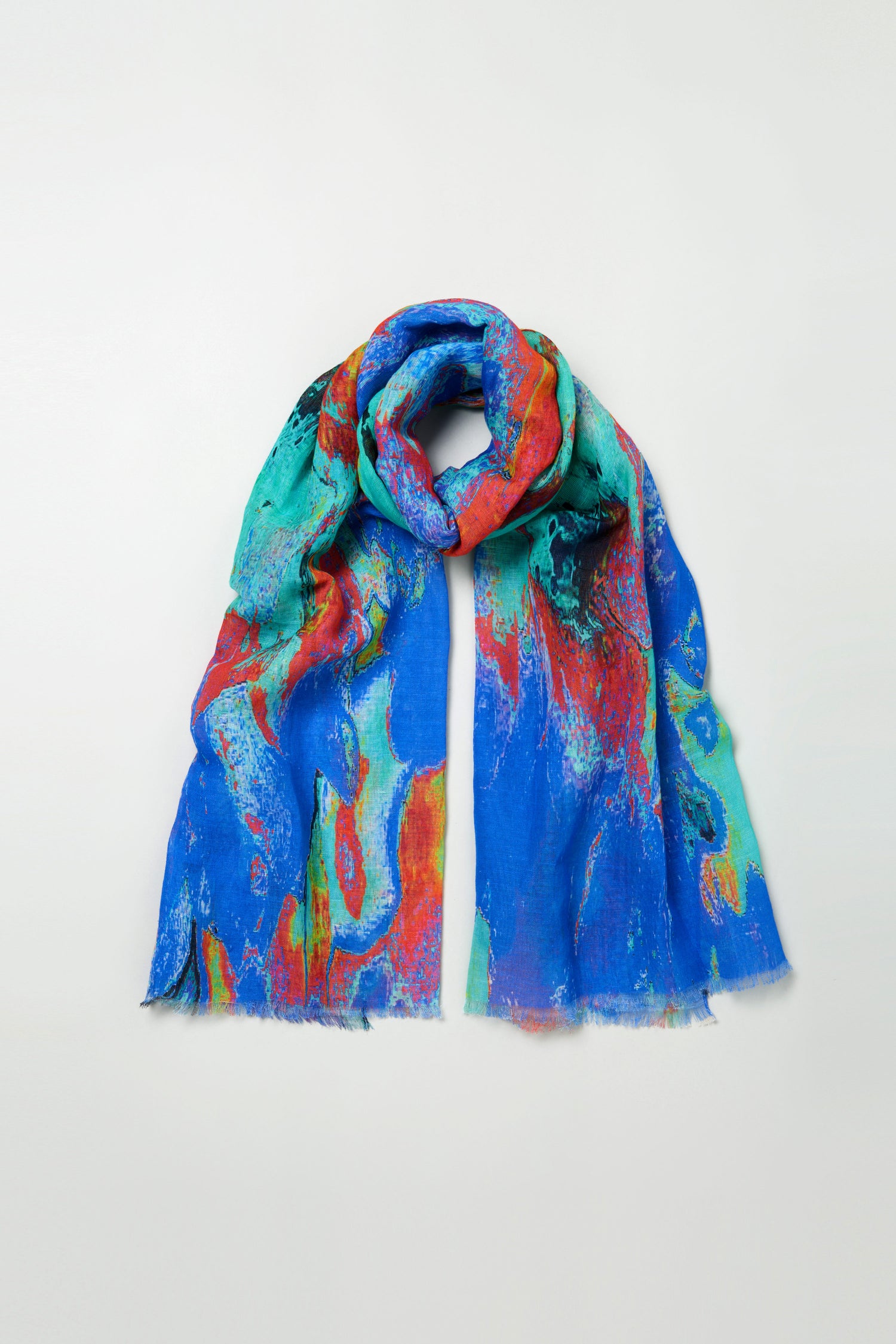 The Terra Mare Cotton Linen Scarf features a vibrant abstract pattern in blue, red, turquoise, and black, set against a plain light background.