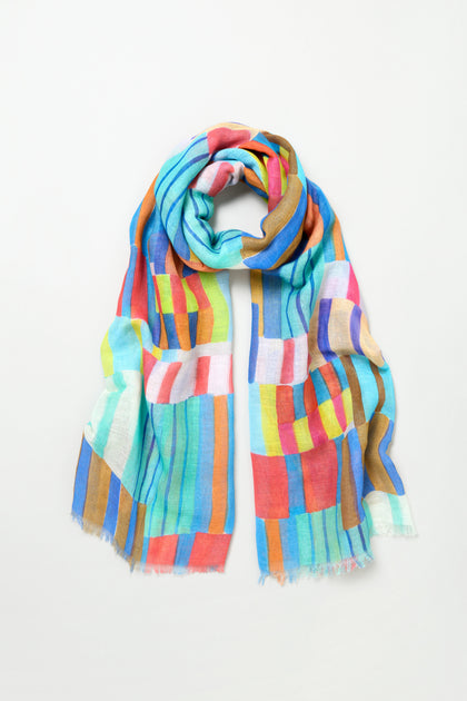 The Vivid Painted Stripes Scarf is a lightweight cotton-linen accessory featuring colorful rectangular blocks in blue, orange, green, red, brown, and white, shown against a plain white background.