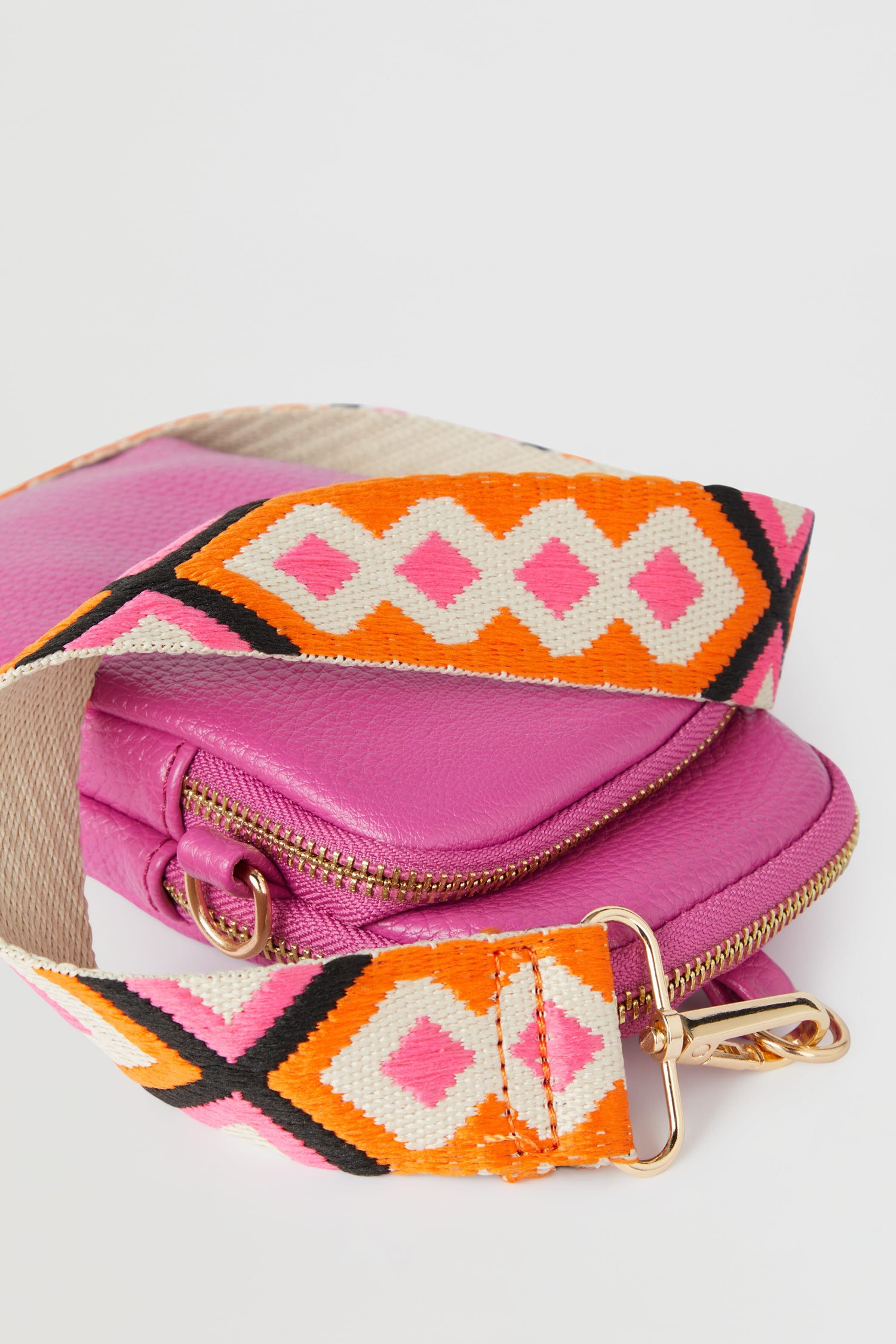 A Mini Crossbody Bag in a stylish pink and orange pattern.