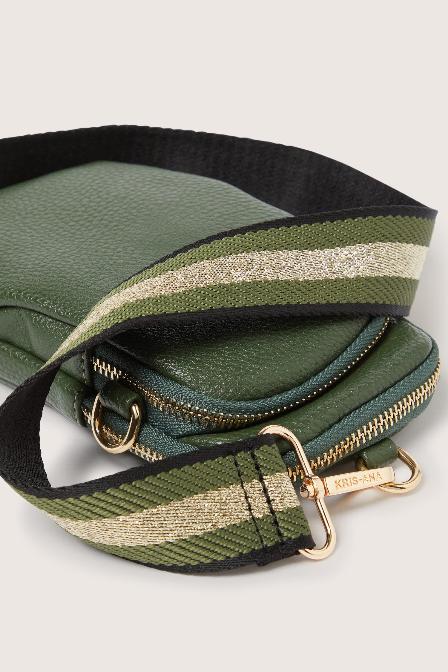 A stylish green leather Mini Crossbody Bag by Kris-Ana with a gold striped strap.