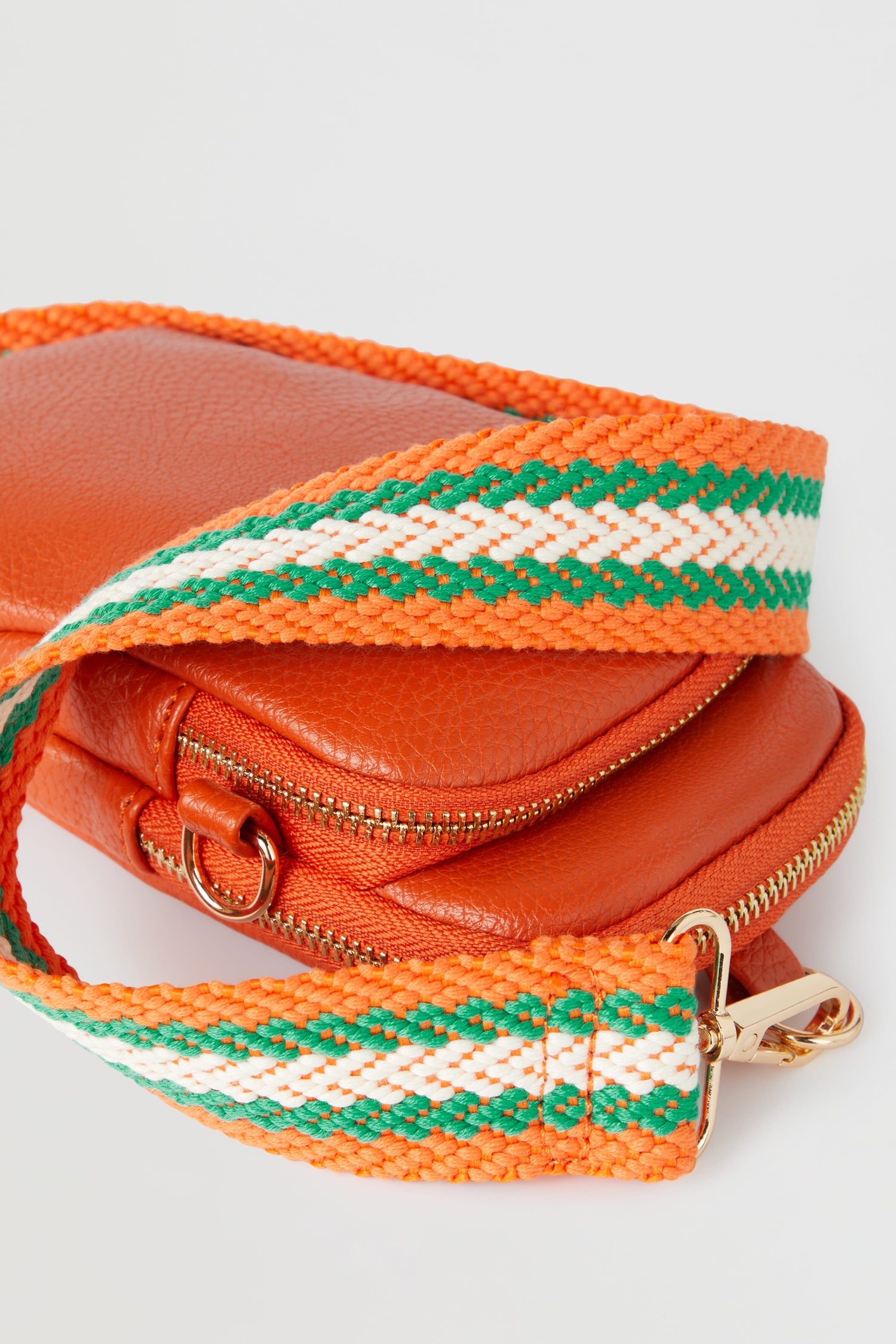 An orange Mini Crossbody Bag with green and white stripes.