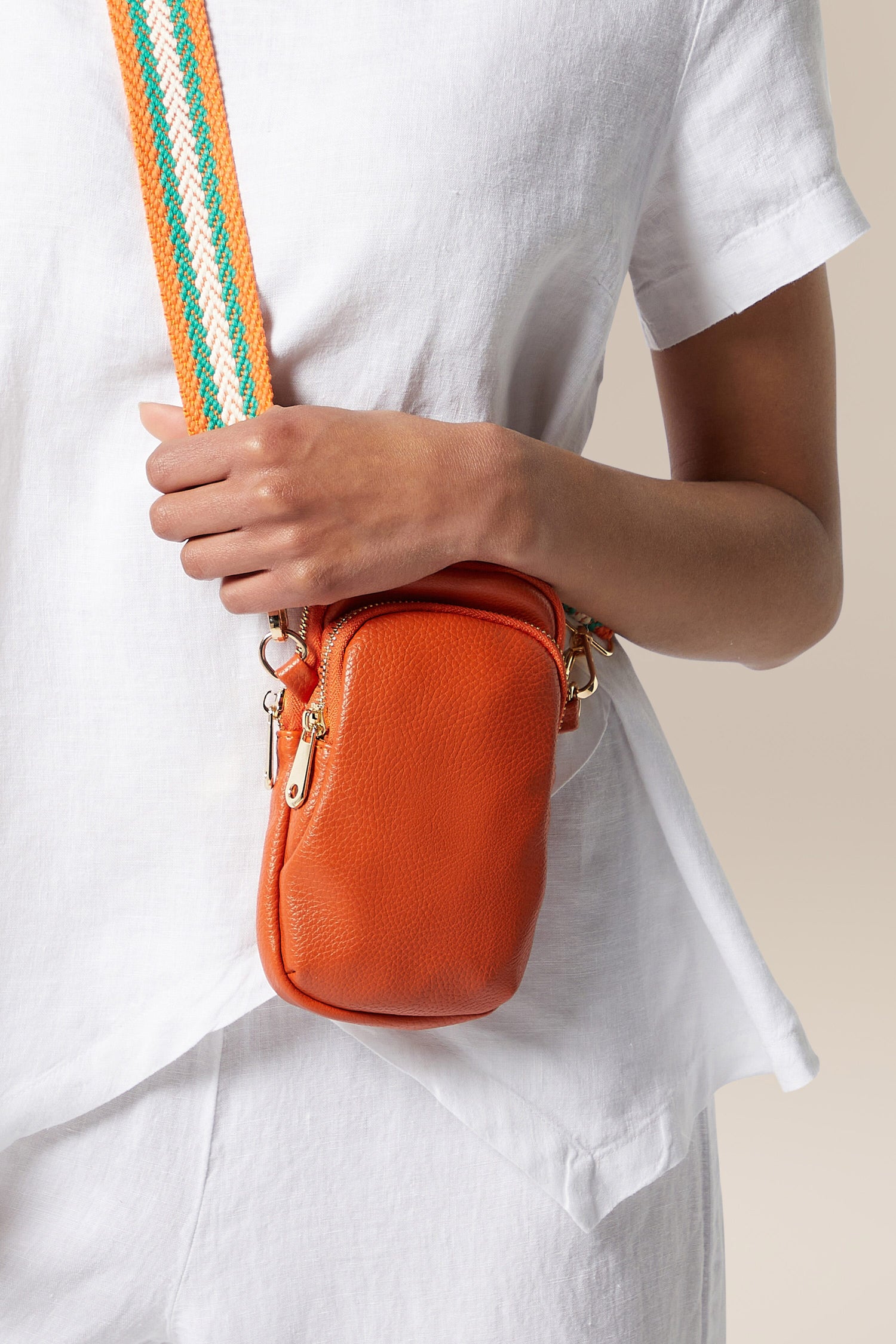 A woman is showcasing a stylish Mini Crossbody Bag.