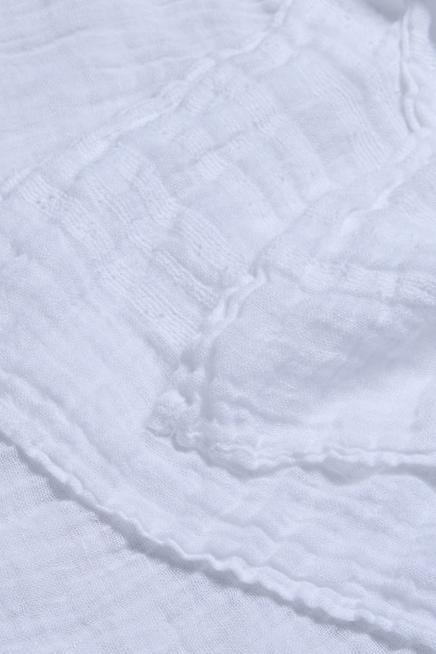 Close-up of the Crinkle Linen Scarf in white, showcasing its lightweight, semi-transparent fabric and natural crinkled texture.