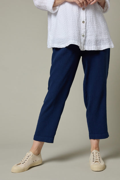 A woman wearing a white shirt and blue Twisted Linen Slim Trouser.