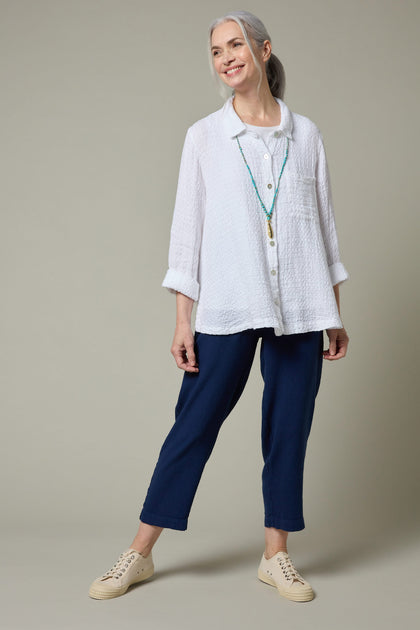 A woman wearing a Twisted Linen Slim Trouser and blue pants.