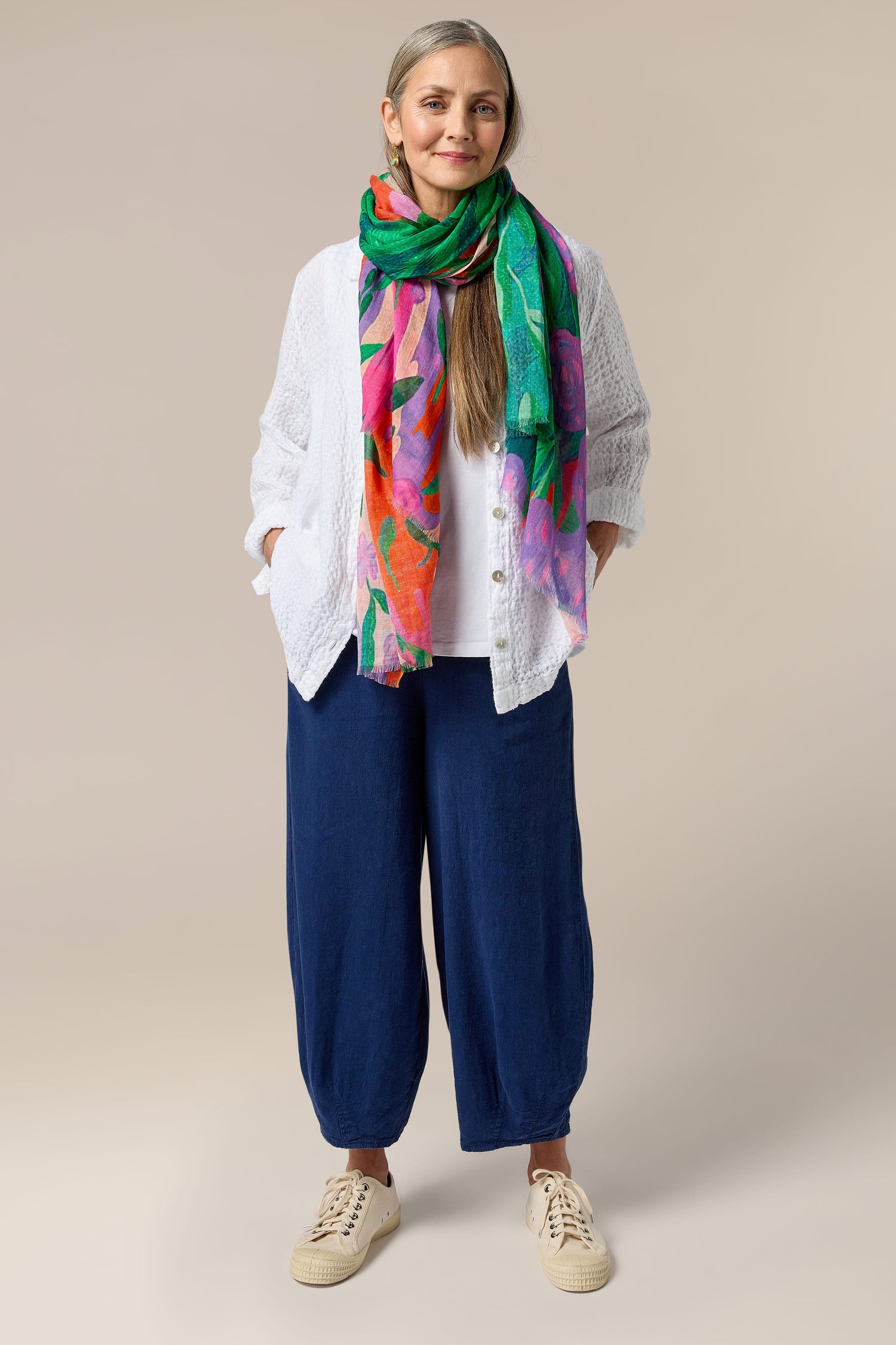 A woman wearing a colorful linen scarf and Twisted Linen Bubble Trouser.