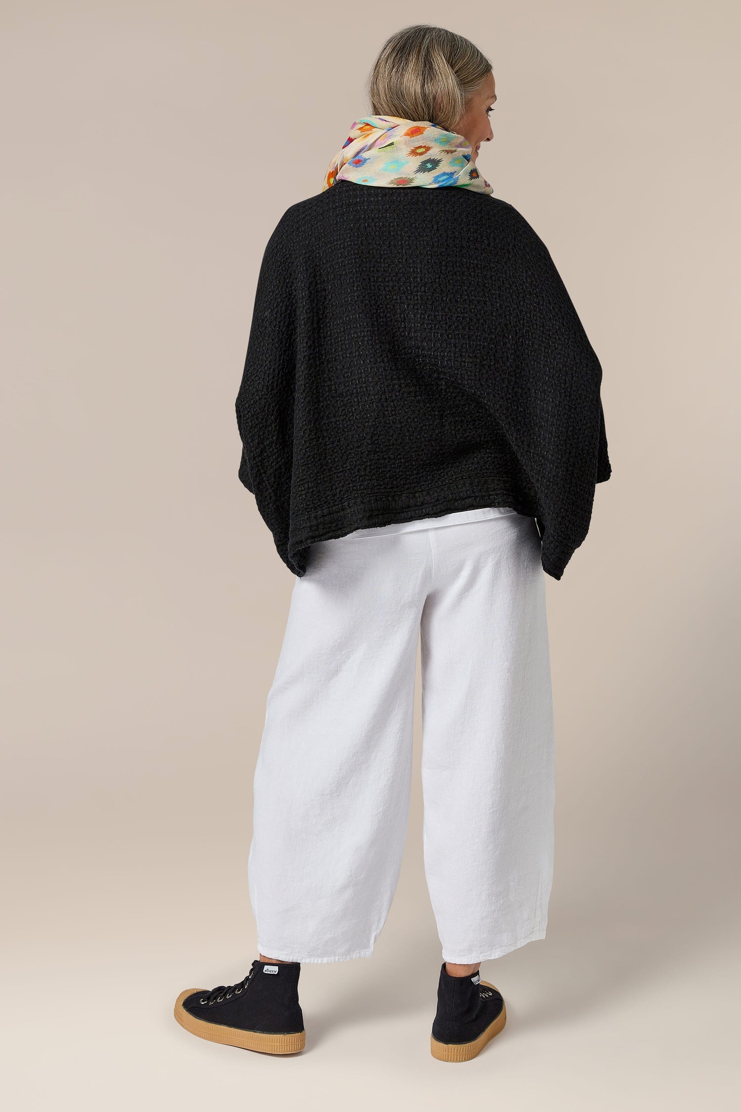 The back view of a woman wearing a black sweater and the Twisted Linen Bubble Trouser with an elasticated waistband.