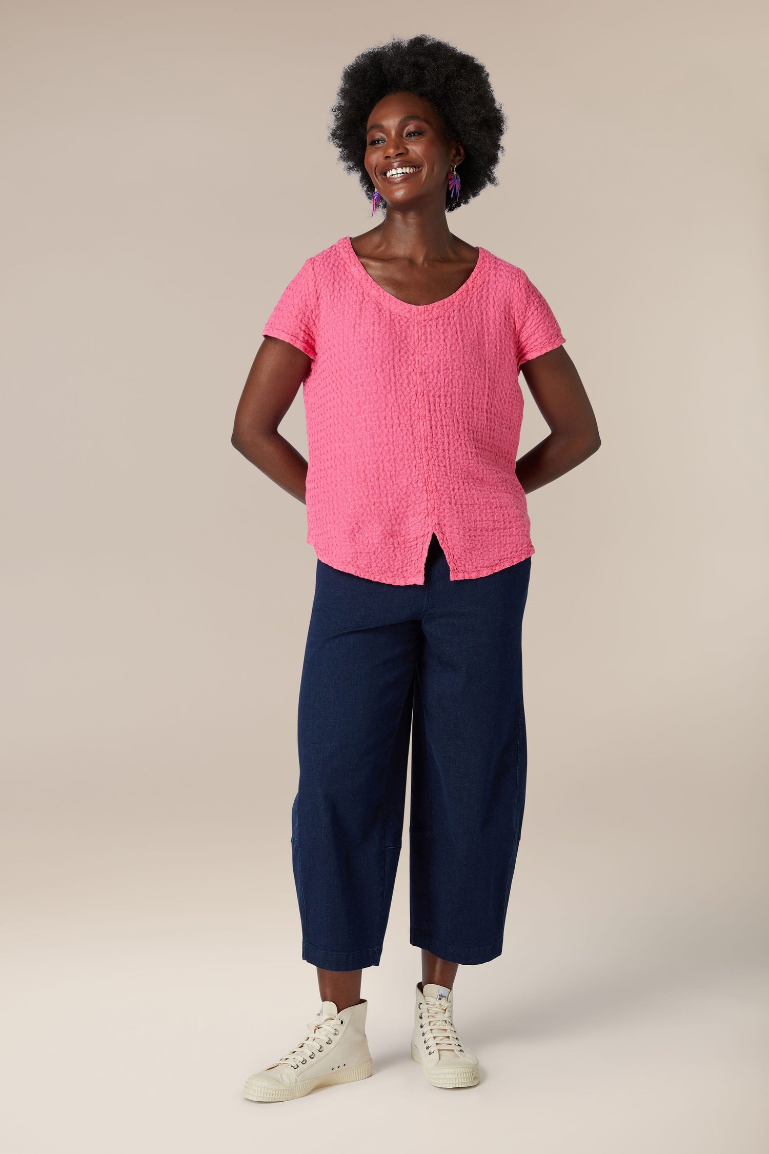 A woman in a soft Waffle Linen Top pink and blue pants.