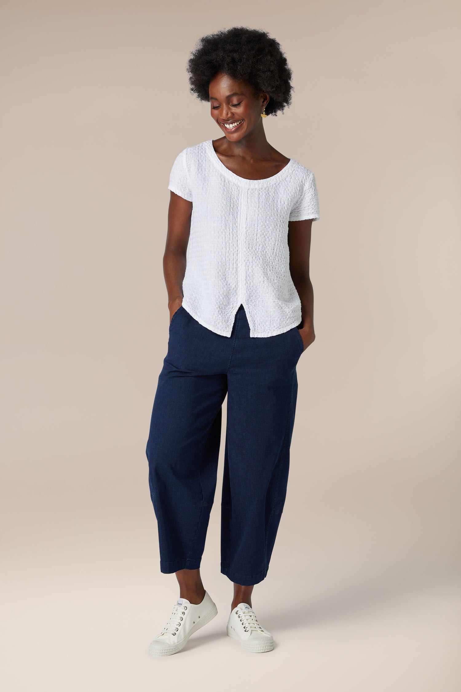 A woman wearing a soft Waffle Linen Top and navy pants.