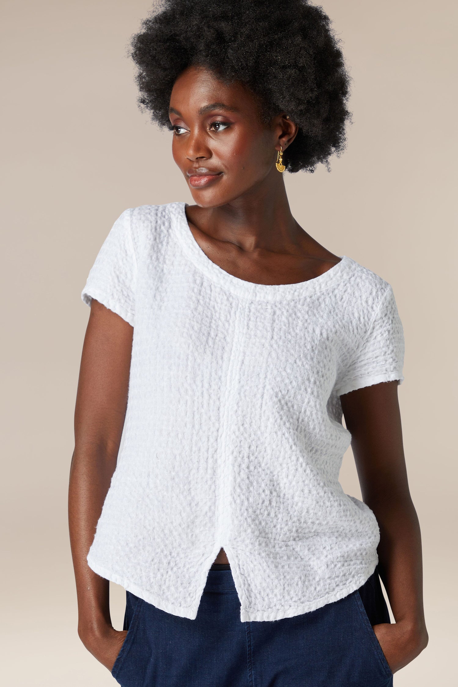 A black woman wearing a white soft Waffle Linen Top and blue pants.