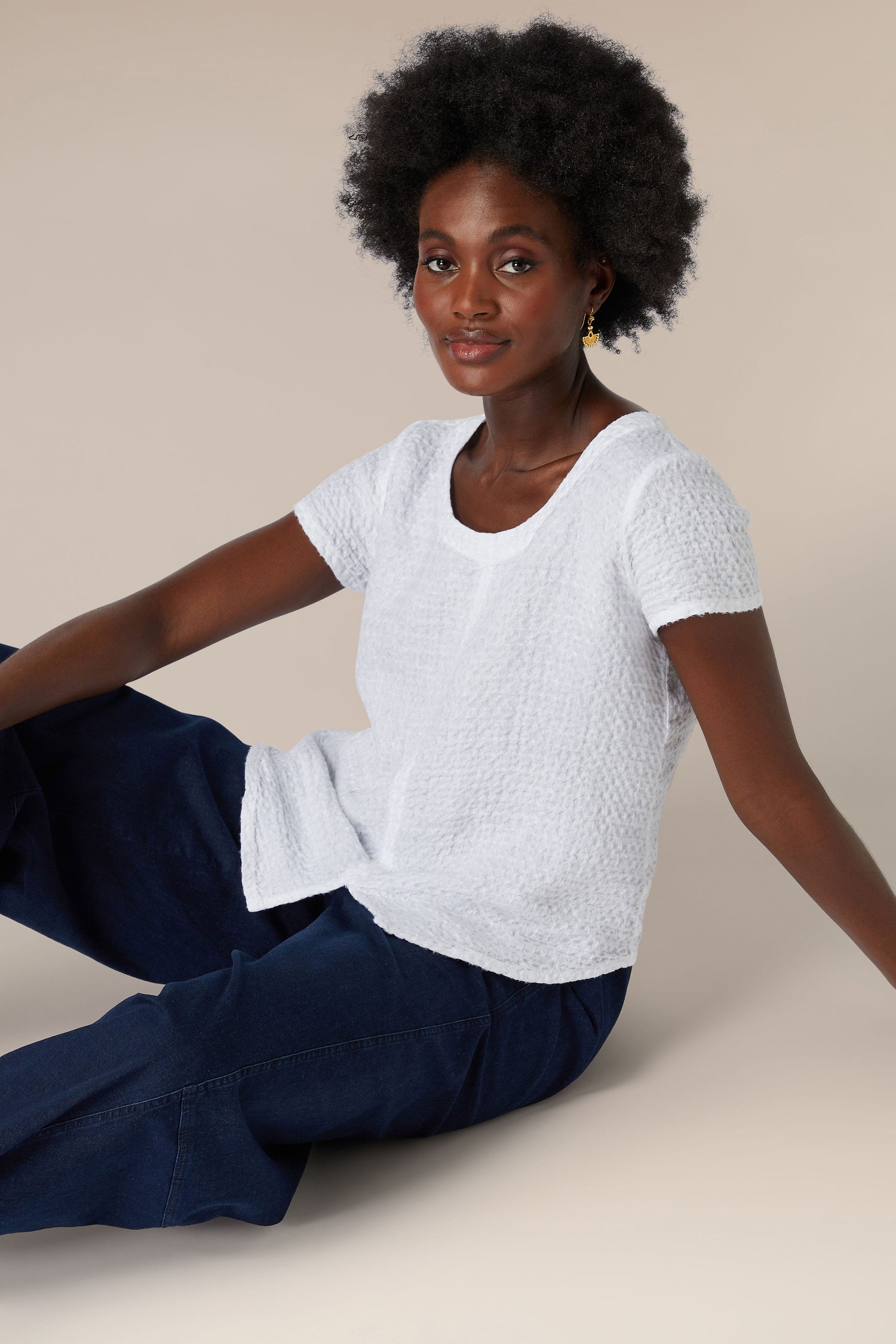 A woman sitting on the floor wearing a soft Waffle Linen Top.