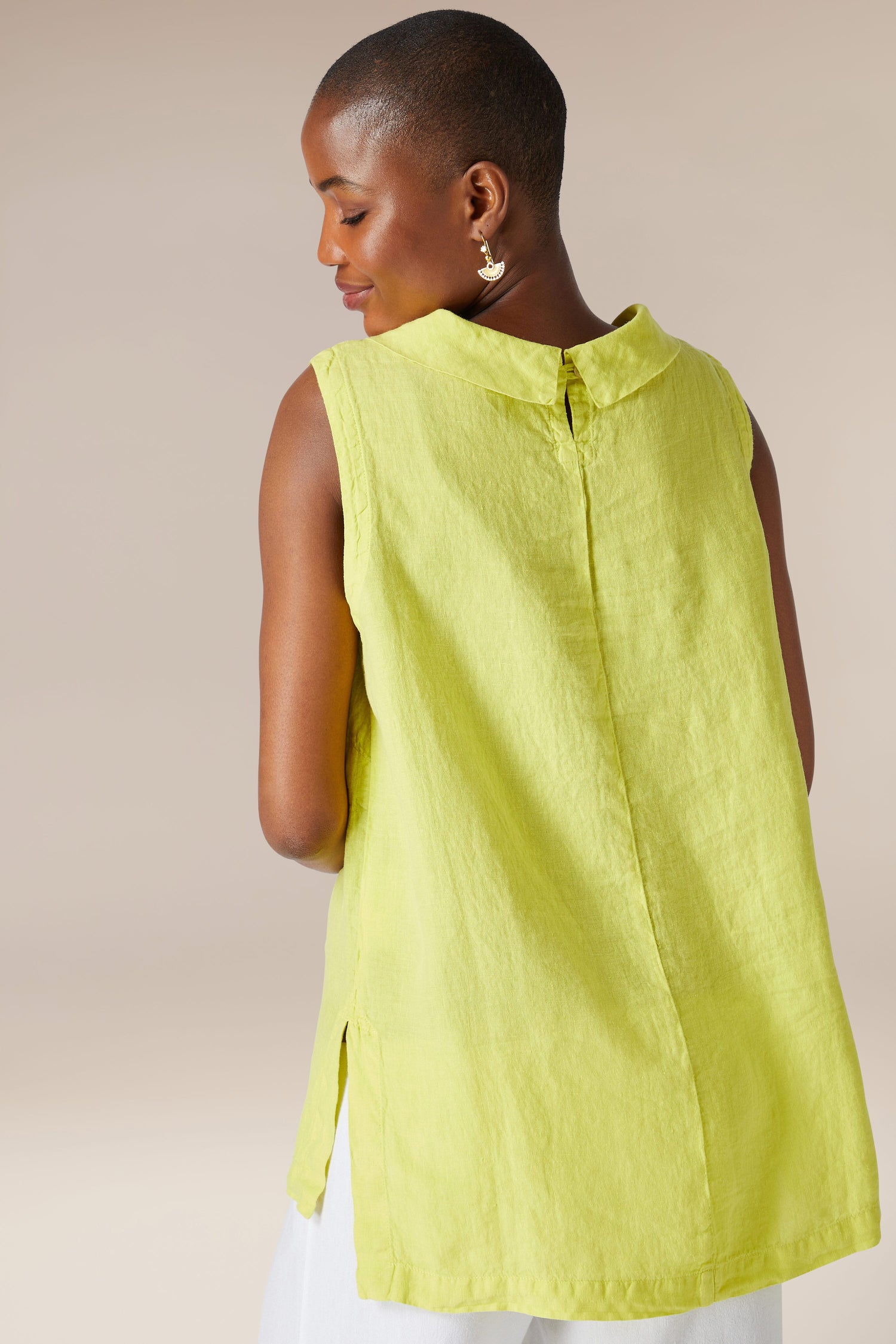 Woman wearing an Organza Linen Cowl Vest and white pants, viewed from behind, against a neutral background.