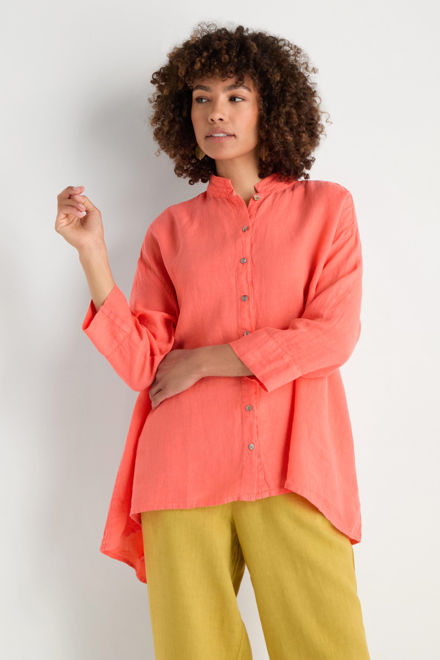 A person wearing the Organza Linen Flared Shirt in coral, featuring a small collar, shown from shoulders to chin.