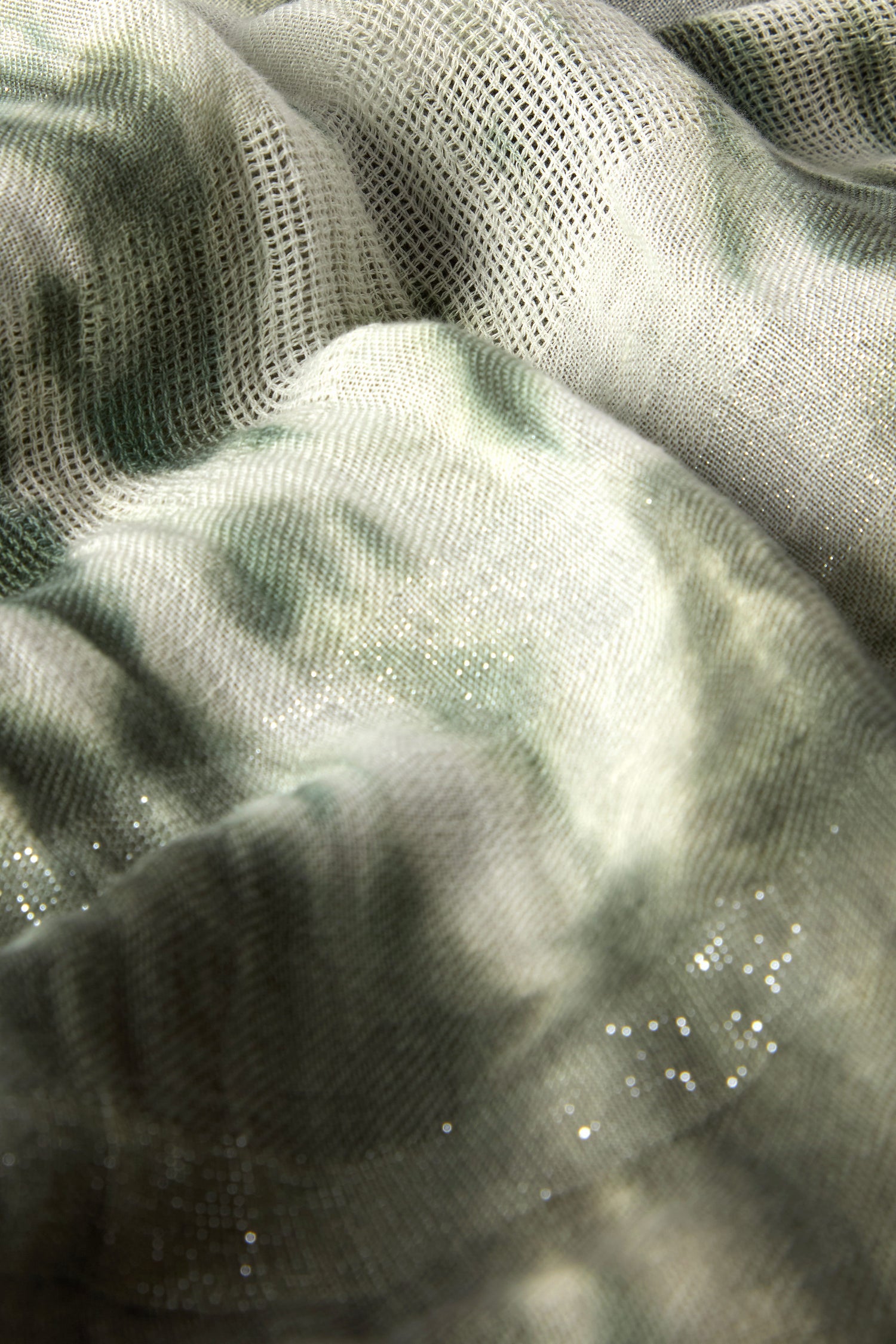 Close-up of light and dark khaki green textured fabric with a mesh pattern and sparkling details, reminiscent of a Sparkle Tie Dye Linen Mix Scarf.