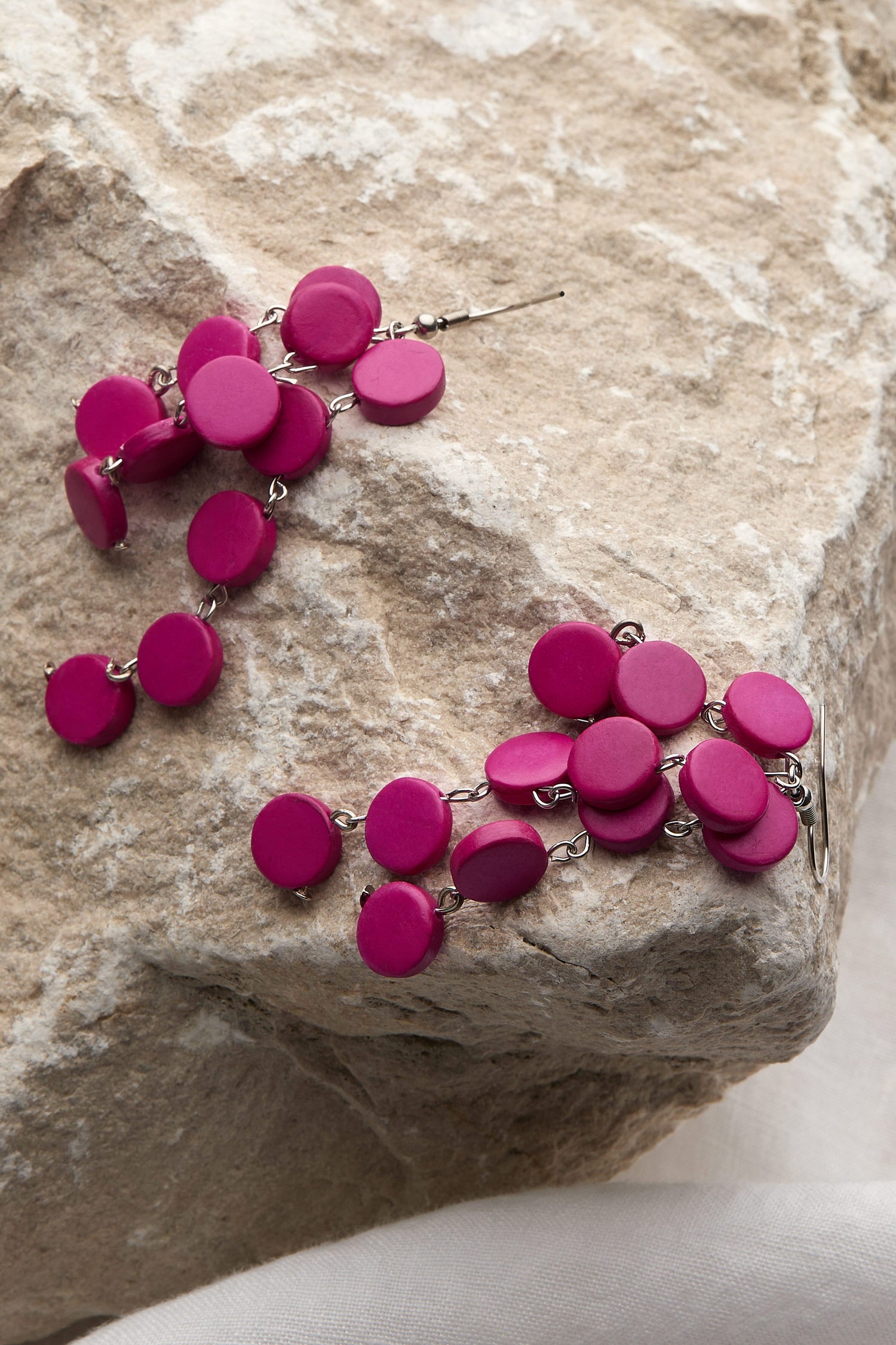 A pair of Cascade Earrings handcrafted by local artisans resting on a rock.