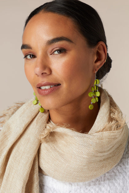 A woman wearing a scarf and Cascade Earrings.