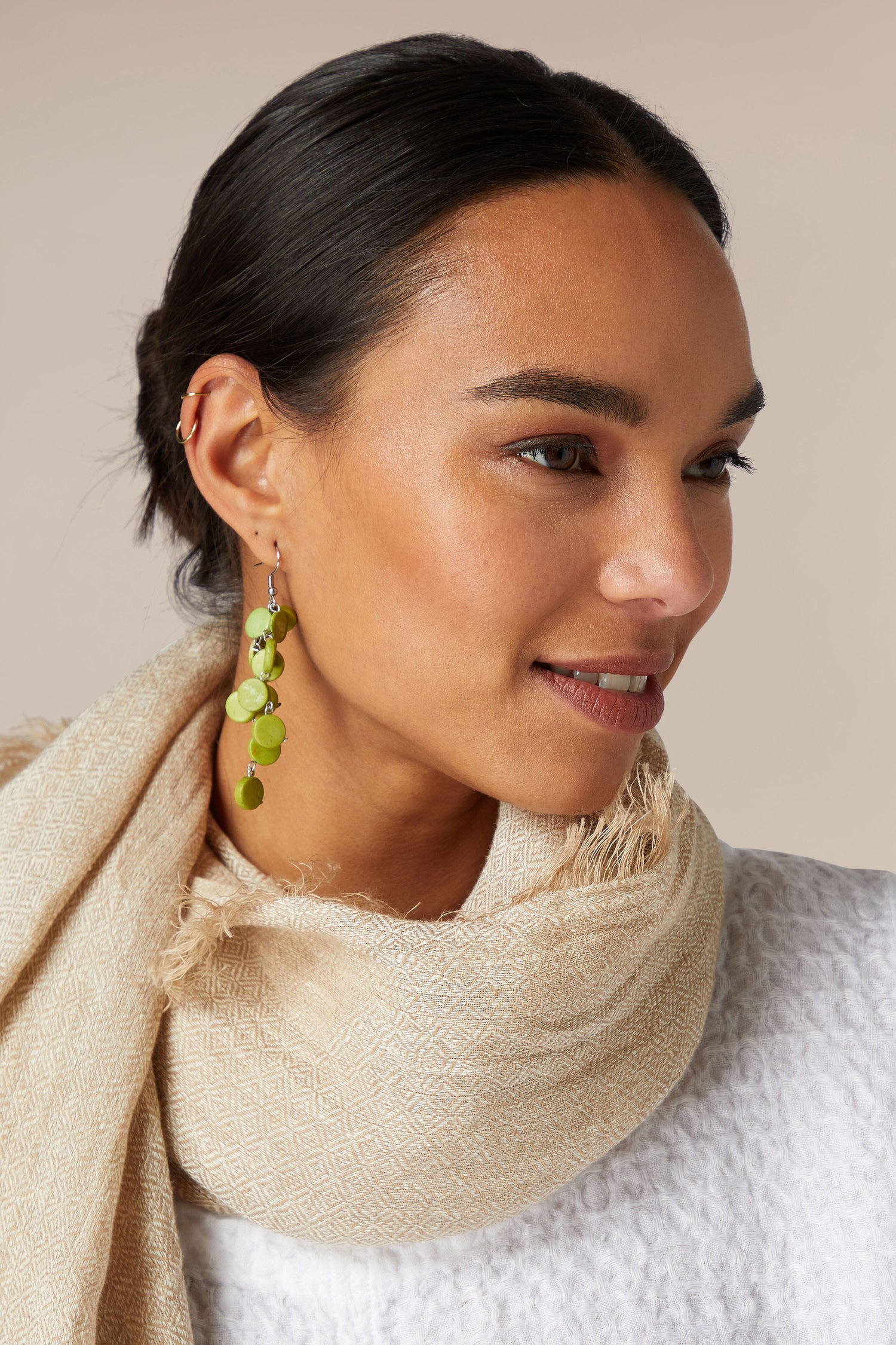 A woman wearing a scarf and Cascade Earrings.